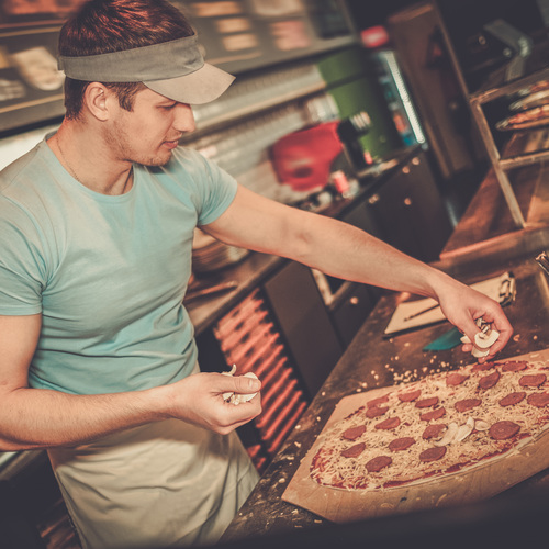 Pizzaiolo travaillant dans une pizzeria ...
